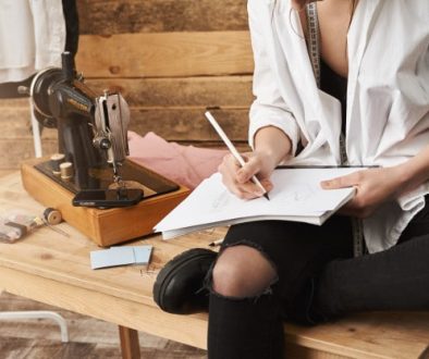 when-hobby-become-real-work-cropped-shot-creative-female-designer-clothes-sitting-table-near-sewing-machine-her-workshop-making-notes-planning-new-design-her-clothing-line_176420-14572-1 (1)